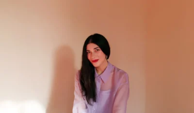 a portrait of Laura Elizabeth Wollett. She has long black hair and red lipstick